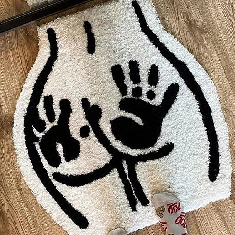 Tufted black and white floor rug featuring a bum with hand prints on